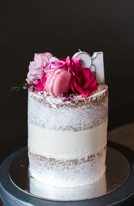 Custom birthday cake with fresh pink flowers and macrons