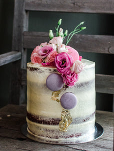 Celebration cake decorated with fresh flowers, macarons and gold leaf custom made for a birthday